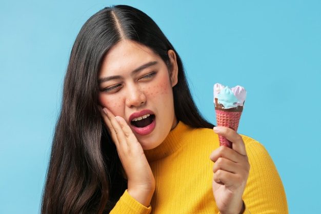 Mujer comiendo un helado, l que según los consejos de dentistas genera sensibilidad dental