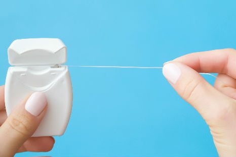 persona haciendo uso del hilo dental