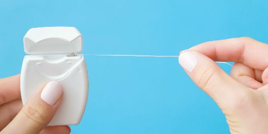 persona haciendo uso del hilo dental