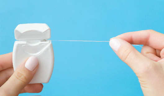 persona haciendo uso del hilo dental