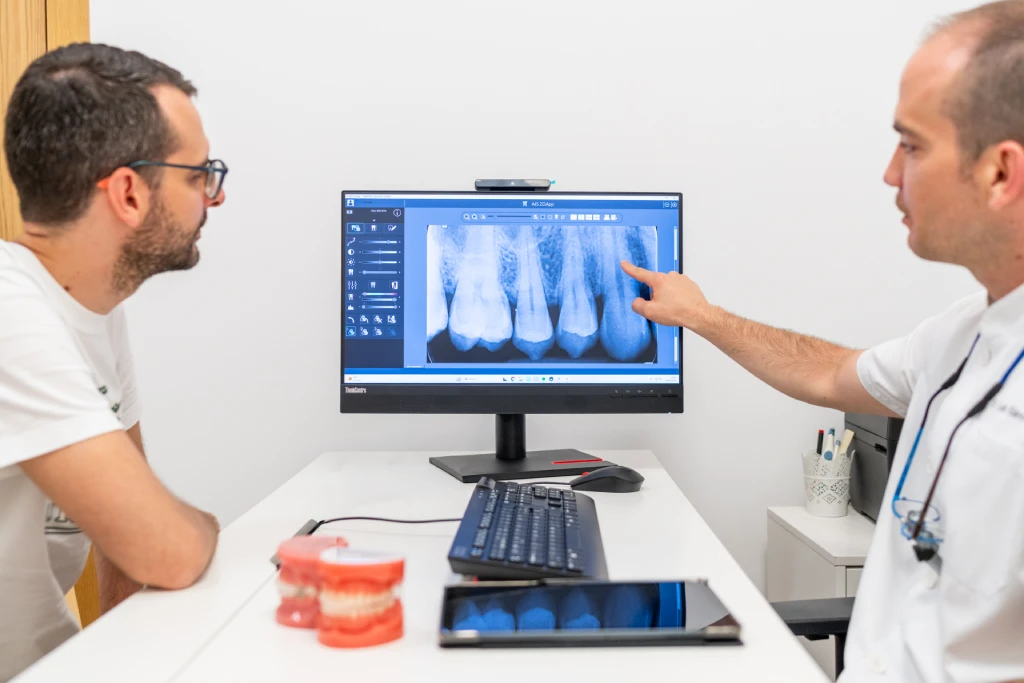 Odontólogo mostrando una radiografía para valorar una endodoncia en Getxo