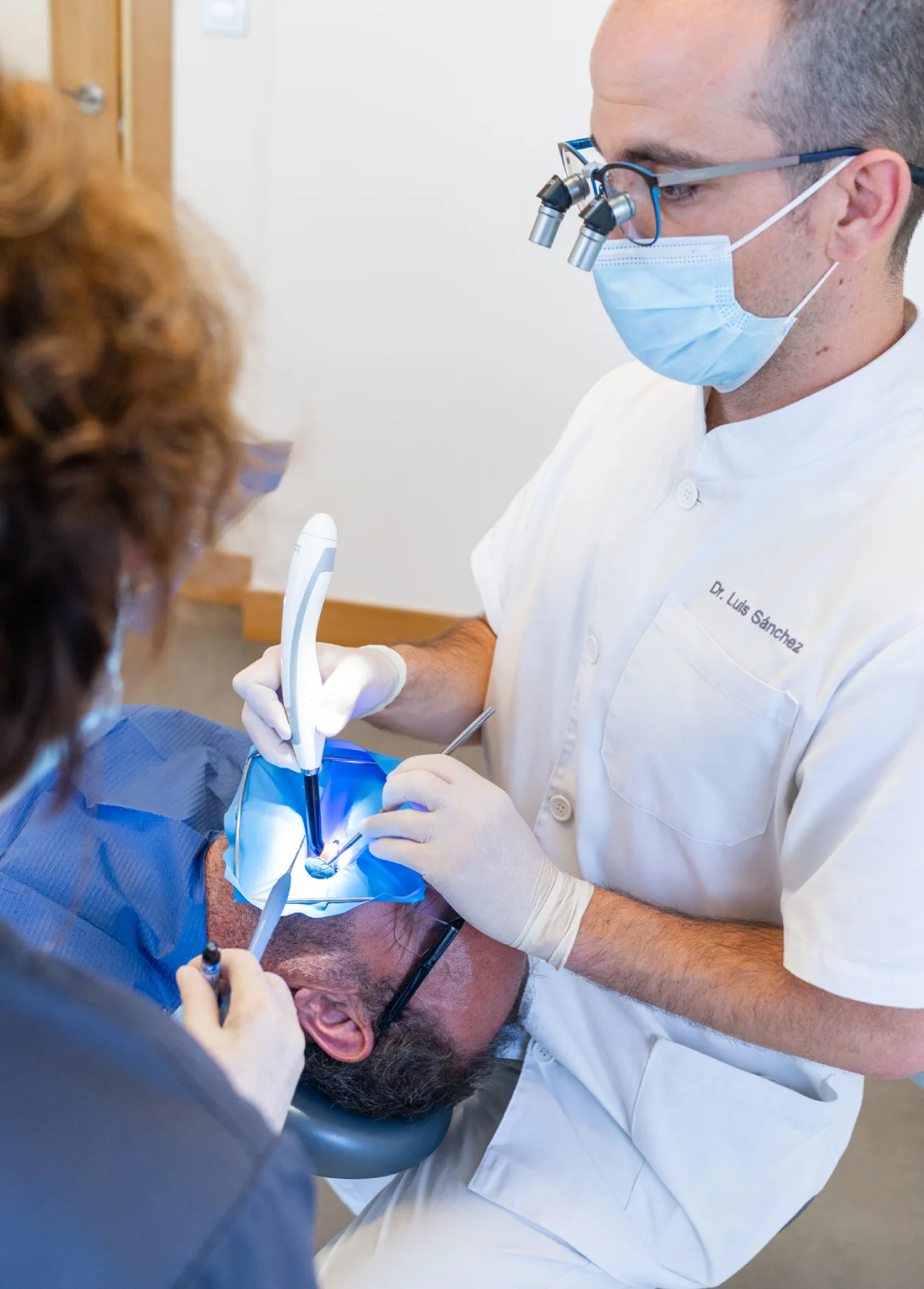 Dr. Luis Sánchez tratando a un paciente con lupas de aumento en Getxo